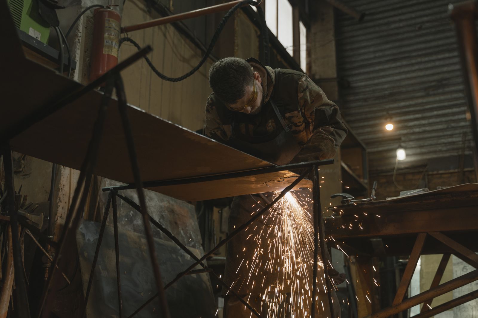 A welder at work sending up a shower of molten sparks in the shop
